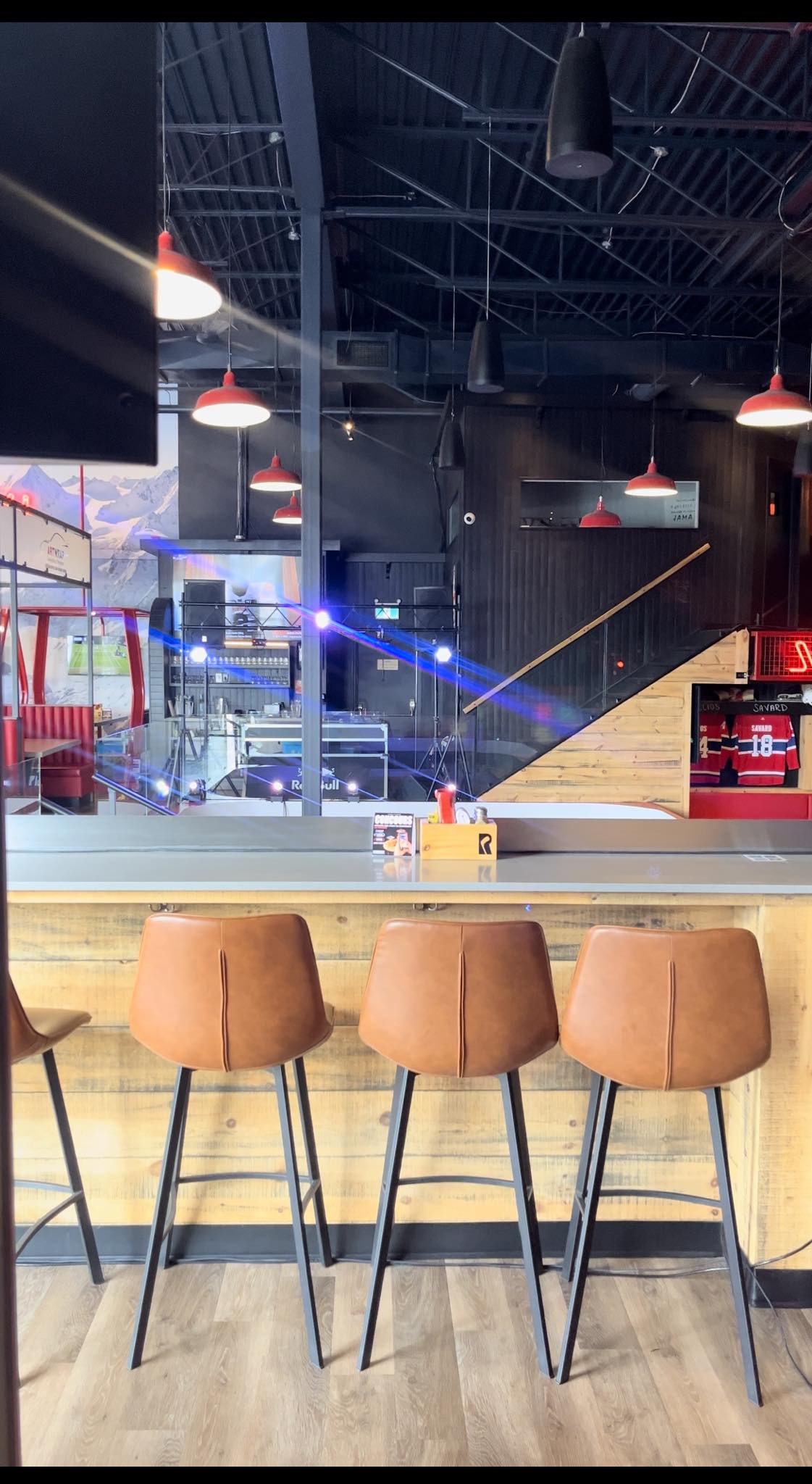 Régie et faisceaux lumineux bleus installés dans un bar, vus depuis le comptoir